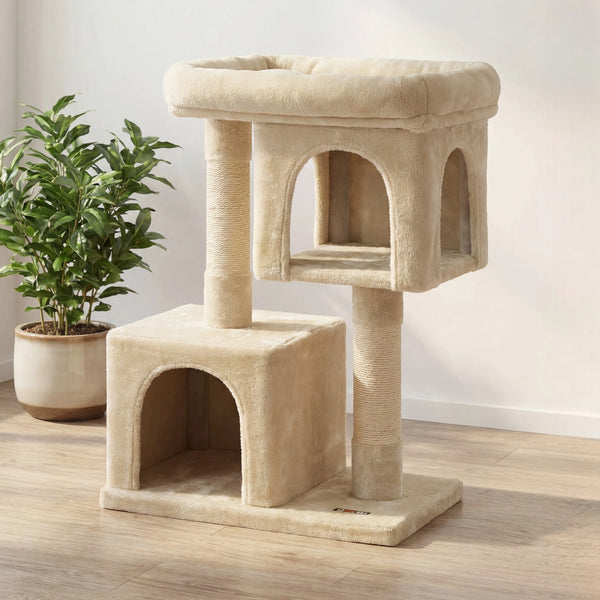Petit arbre à chat beige compact avec deux niches superposées et perchoir moelleux, plante verte en arrière-plan