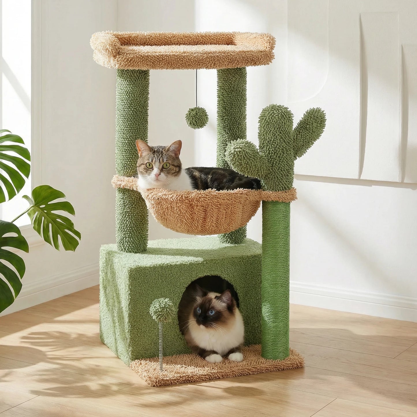 Arbre à chat cactus vert et beige avec hamac et niche, deux chats installés et plante monstera en arrière-plan