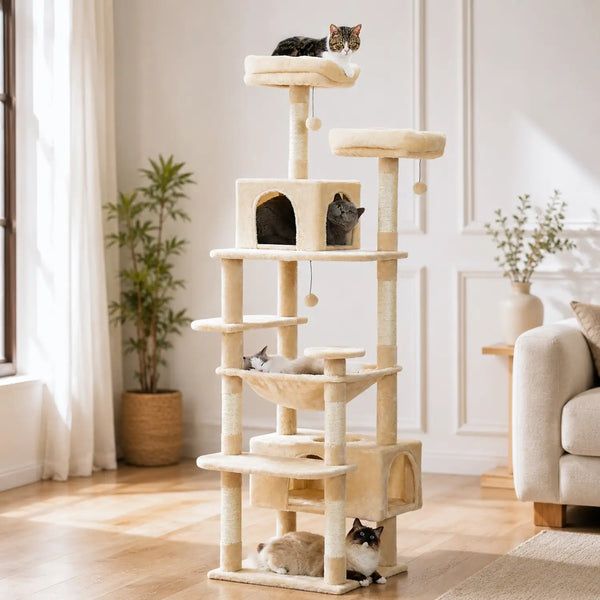 Arbre à chat beige multi-niveaux avec niches fermées, plateformes, hamacs et jouets suspendus, trois chats visibles.
