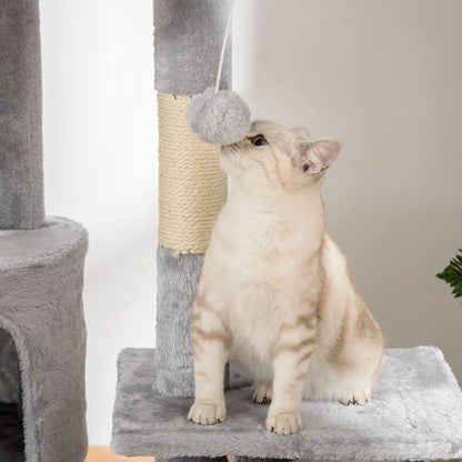 Gros chat blanc assis sur la plateforme d'un arbre à chat fixation plafond gris