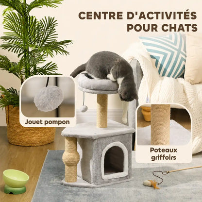 Chat gris explorant un arbre à chat beige avec niche fermée, plateformes et jouet pompon suspendu.